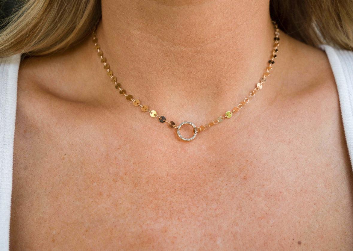 Gold chain necklace with silver circle connector.